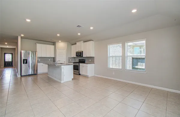 a kitchen with stainless steel appliances granite countertop a refrigerator and a stove top oven