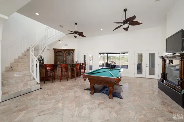 a kitchen with stainless steel appliances granite countertop a stove top oven a sink a dining table and chairs with wooden floor