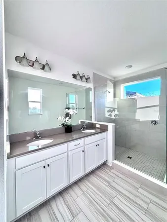 a spacious bathroom with a double vanity sink and a mirror