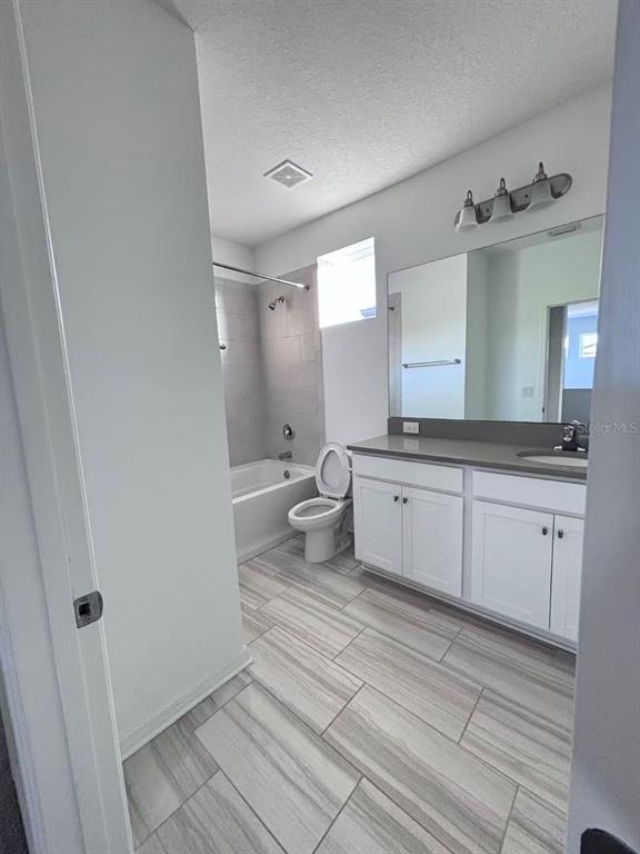 8569 Starlight Loop Parrish, FL 34219 - Photo 5 of 8 a spacious bathroom with a granite countertop sink a toilet and a mirror