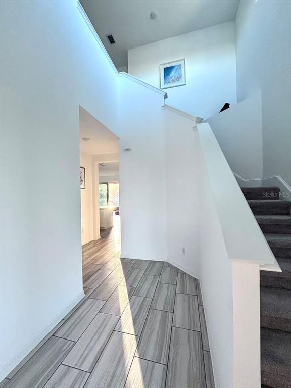 8569 Starlight Loop Parrish, FL 34219 - Photo 6 of 8 a view of a hallway view with wooden floor and staircase