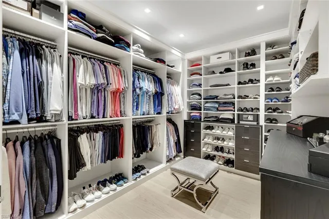 a view of walk in closet with clothes and shoes