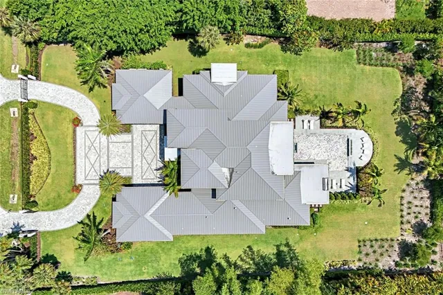 an aerial view of a house with a garden and lake view