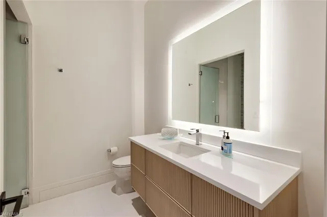 a bathroom with a sink toilet and mirror
