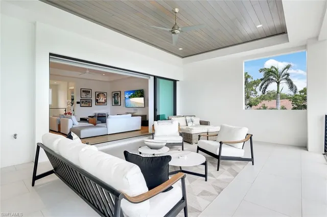 a living room with patio furniture and a large window