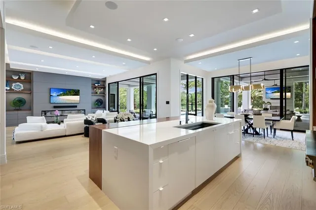 a large white kitchen with a large window and furniture