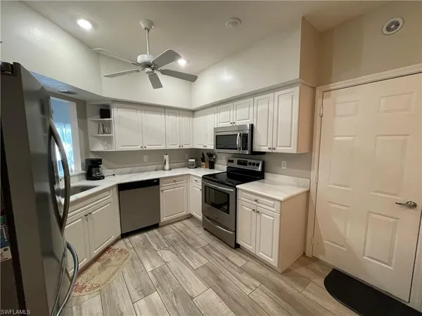 a kitchen with a refrigerator stove and white cabinets