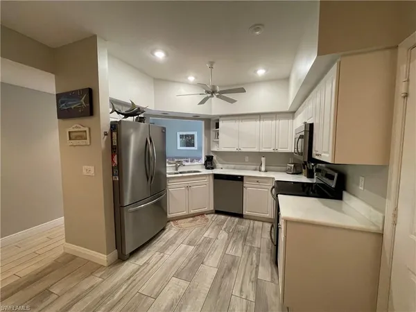 a kitchen with a refrigerator a stove top oven and a sink