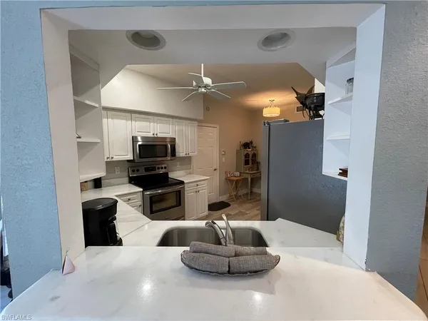 a kitchen with stainless steel appliances kitchen island granite countertop a refrigerator and a sink