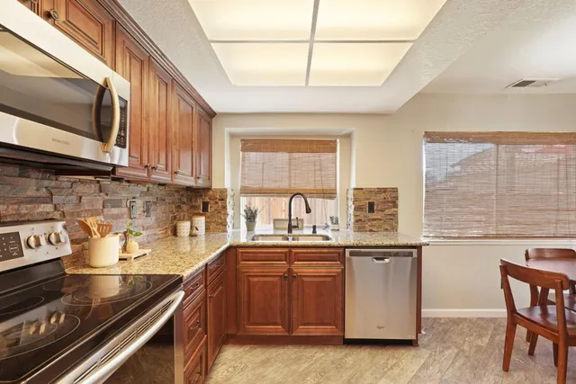 a kitchen with a sink stove top oven and cabinets