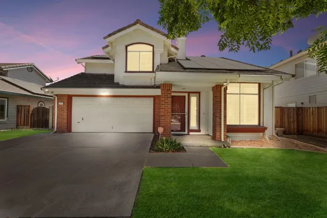 a front view of a house with a garden and plants