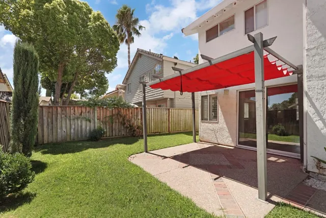a view of a backyard with table and chairs under an umbrella