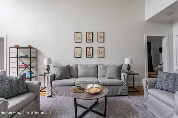 a living room with furniture a rug and a table