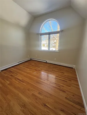 an empty room with wooden floor and a window