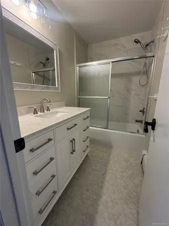 a bathroom with a double vanity sink toilet mirror and shower