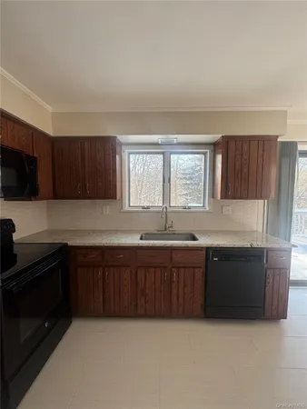 a large kitchen with granite countertop stainless steel appliances stove sink and cabinets
