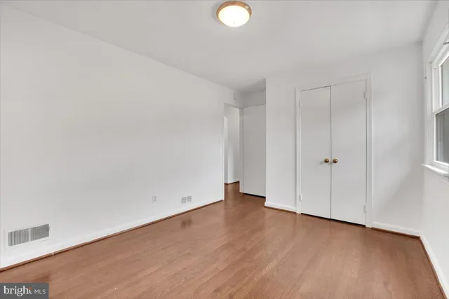 a view of an empty room with wooden floor
