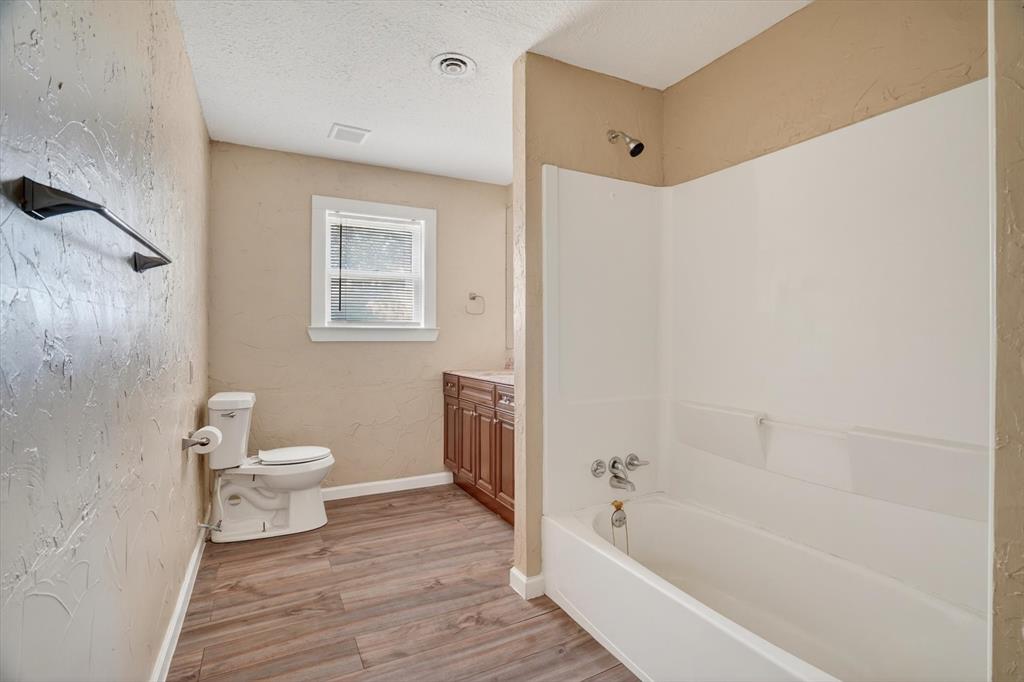 320 North 2nd Street Jacksboro, TX 76458 - Photo 13 of 16 a bathroom with a toilet and a bath tub