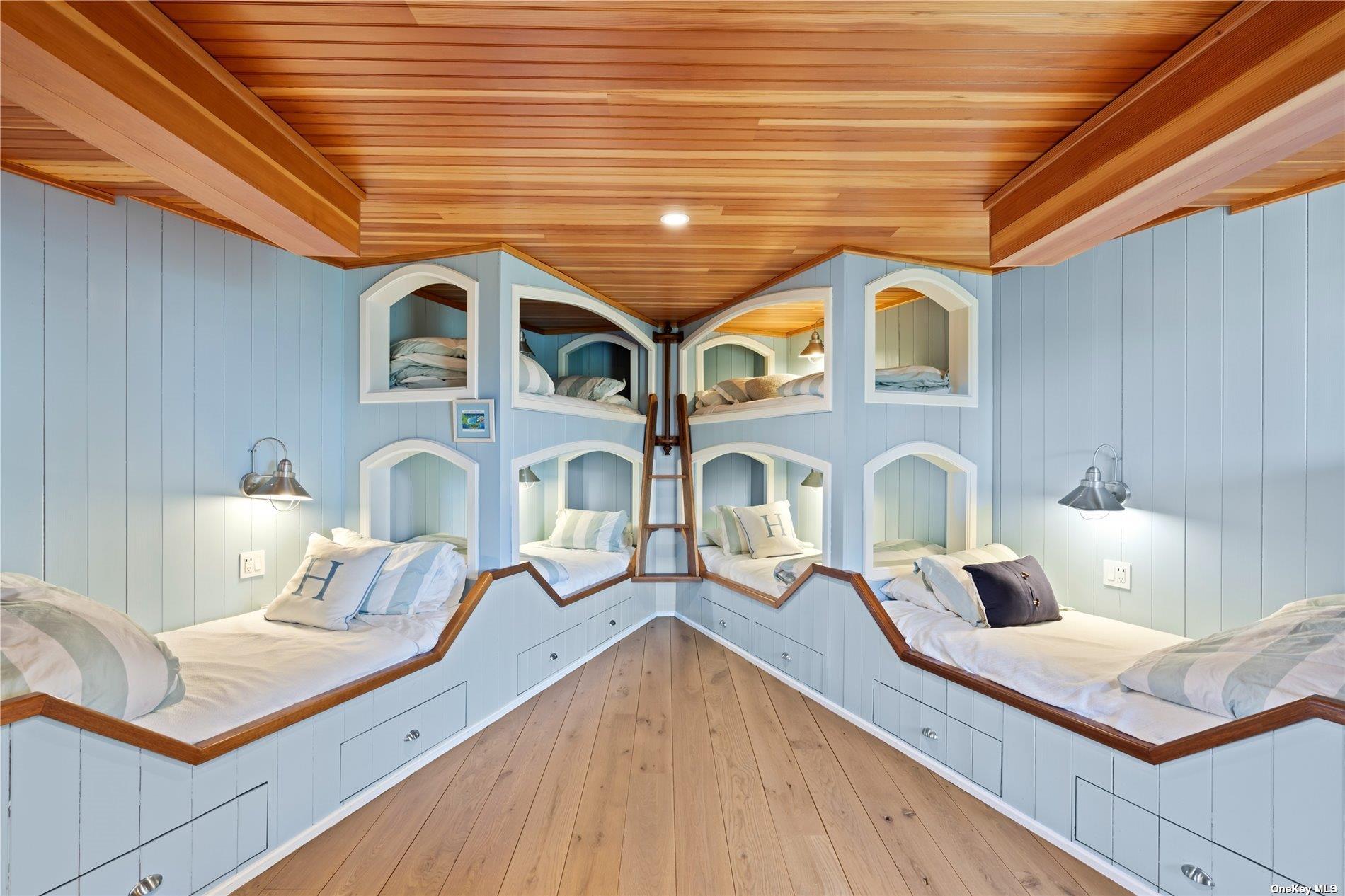 174 Dune Road Quogue, NY 11959 - Photo 26 of 35 a view of living room kitchen with stainless steel appliances wooden floor and chandelier
