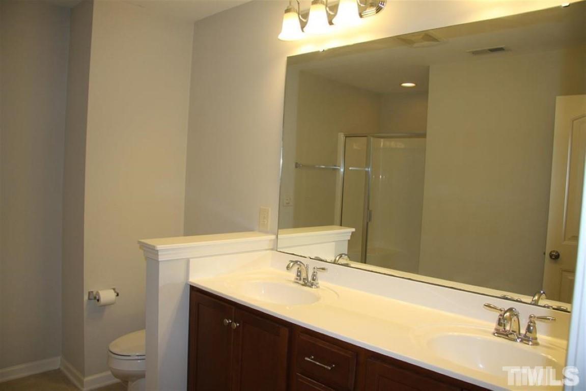 139 Skyros Loop Cary, NC 27519 - Photo 15 of 30 a bathroom with a double vanity sink toilet and a mirror