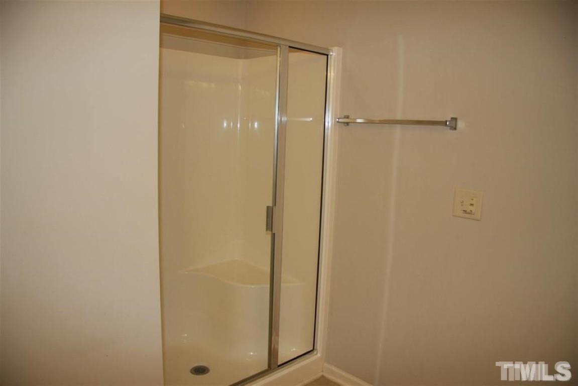 139 Skyros Loop Cary, NC 27519 - Photo 16 of 30 a bathroom with a glass shower door