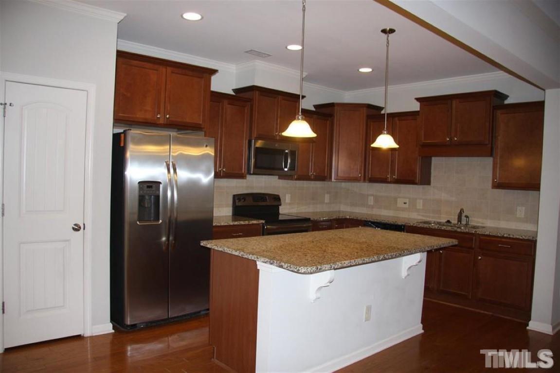 139 Skyros Loop Cary, NC 27519 - Photo 7 of 30 a kitchen with a sink a counter space cabinets and stainless steel appliances