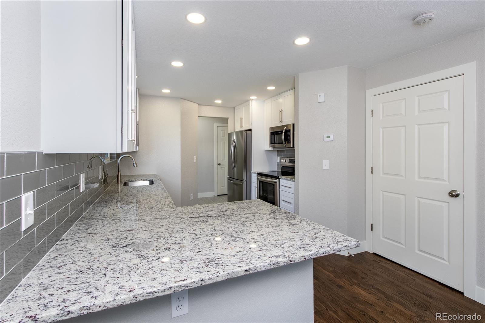 1589 Spring Water Way Highlands Ranch, CO 80129 - Photo 11 of 40 a view of a kitchen with kitchen island granite countertop wooden cabinets and stainless steel appliances