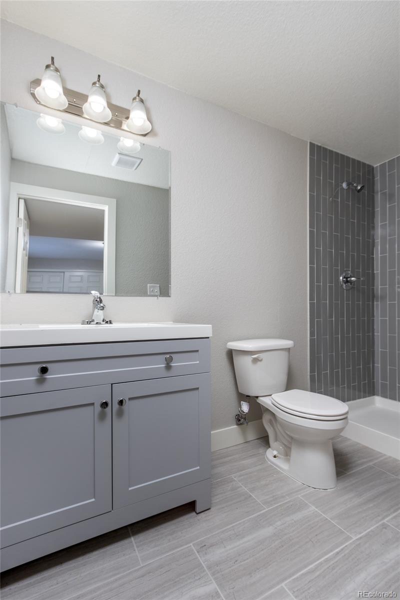 1589 Spring Water Way Highlands Ranch, CO 80129 - Photo 15 of 40 a bathroom with a toilet a sink and mirror