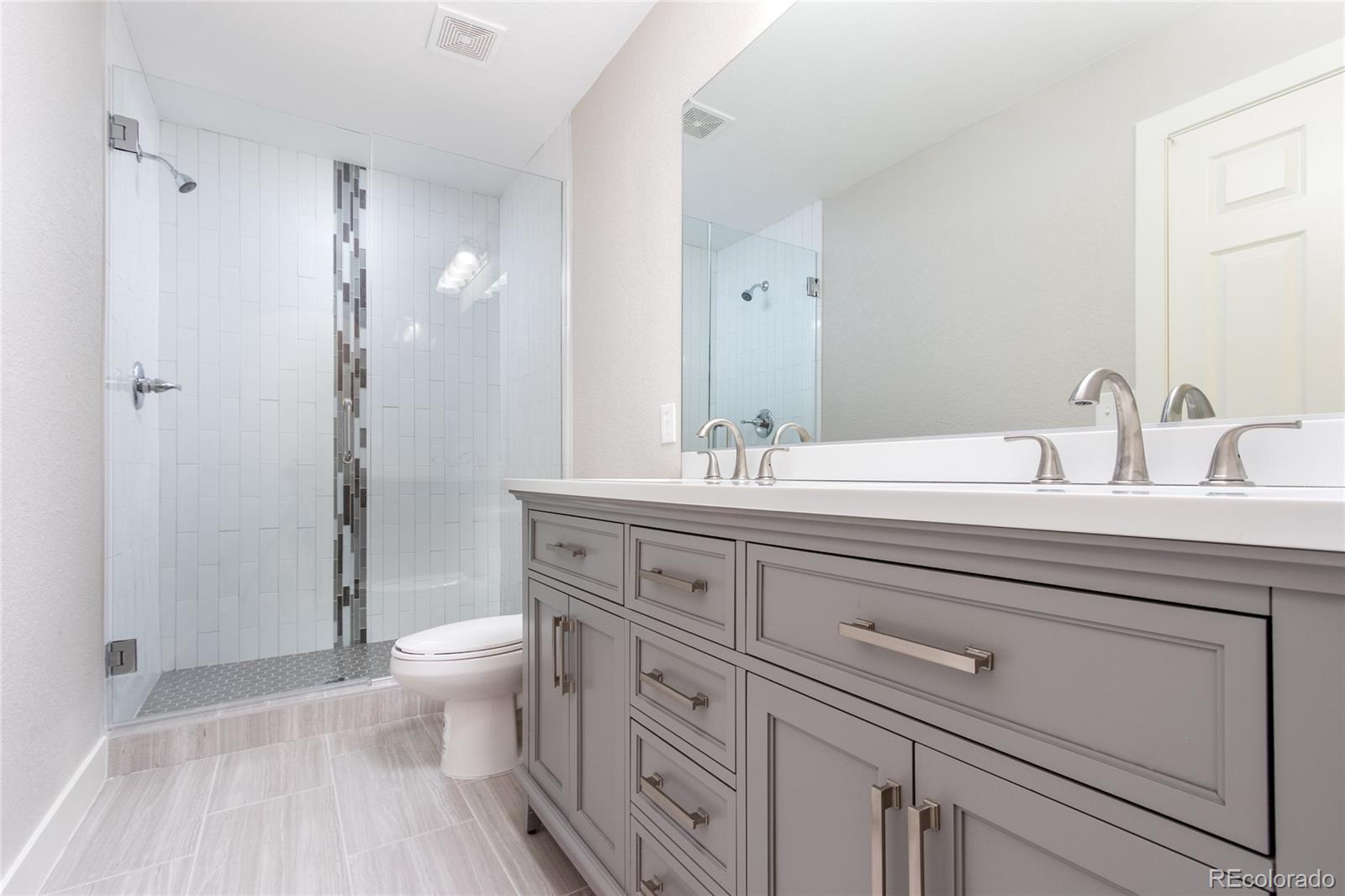 1589 Spring Water Way Highlands Ranch, CO 80129 - Photo 16 of 40 a bathroom with a double vanity sink toilet and shower