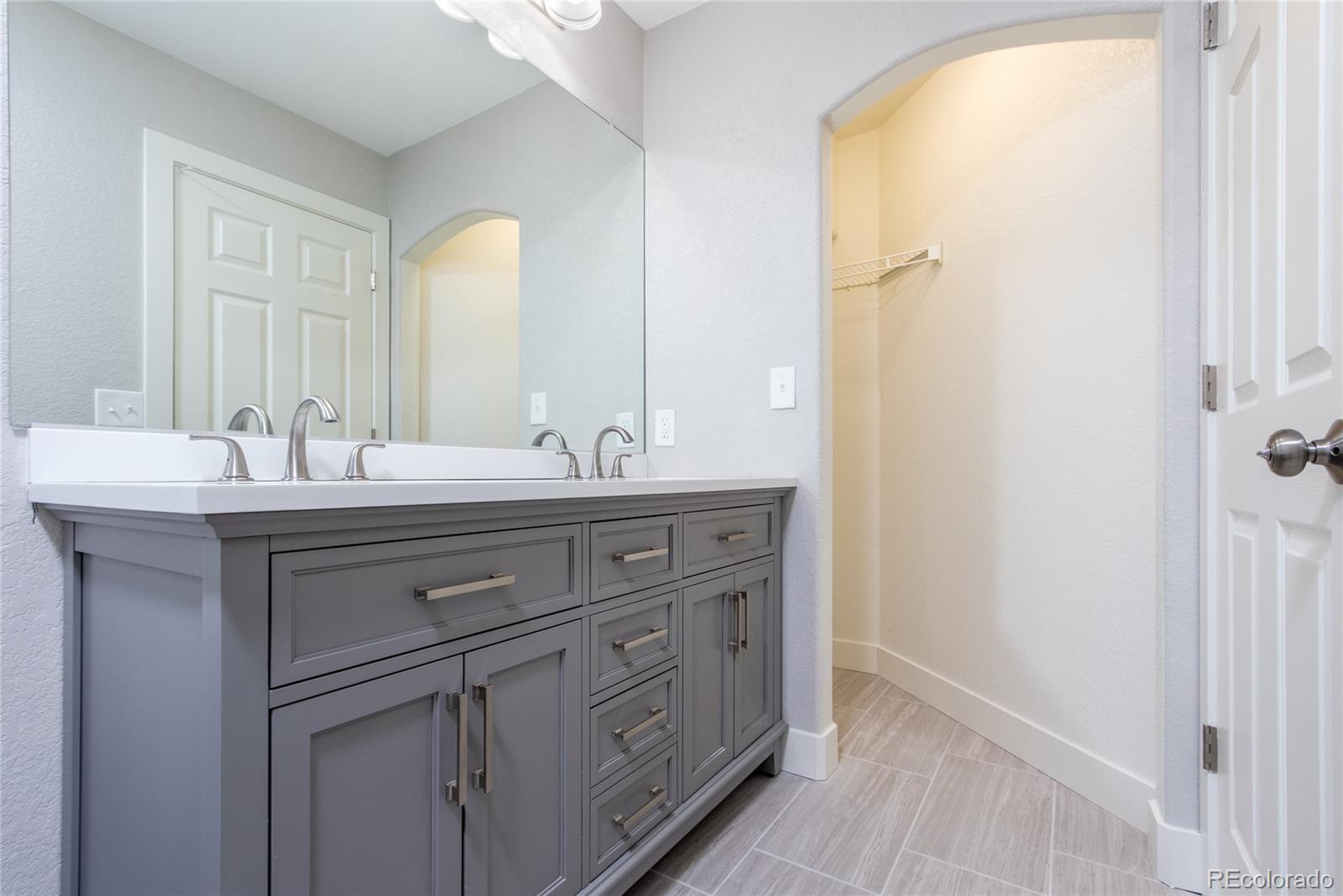 1589 Spring Water Way Highlands Ranch, CO 80129 - Photo 17 of 40 a bathroom with a double vanity sink and a mirror