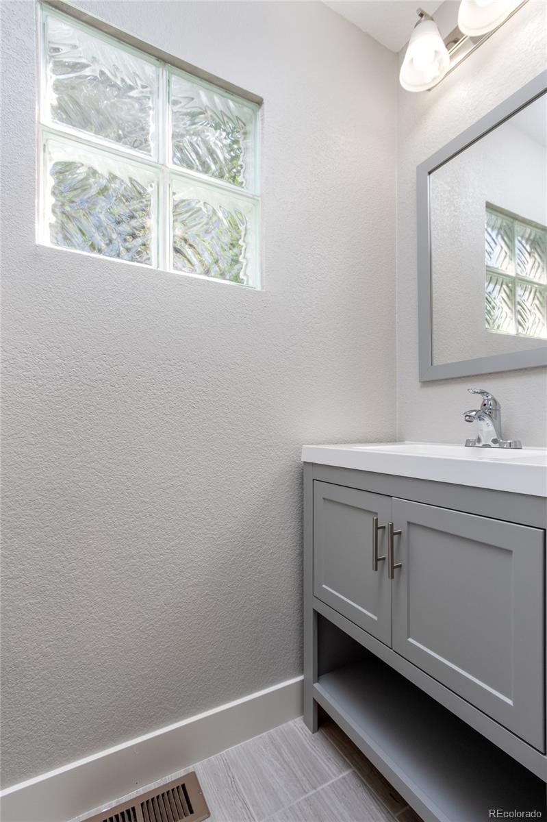 1589 Spring Water Way Highlands Ranch, CO 80129 - Photo 19 of 40 a bathroom with a sink a vanity and a window