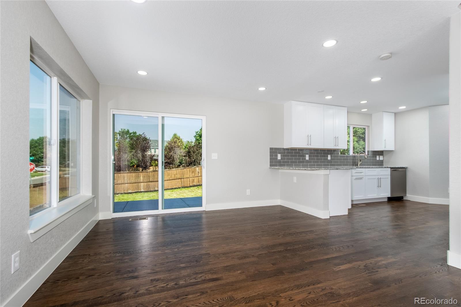 1589 Spring Water Way Highlands Ranch, CO 80129 - Photo 7 of 40 a view of an empty room with wooden floor and a kitchen