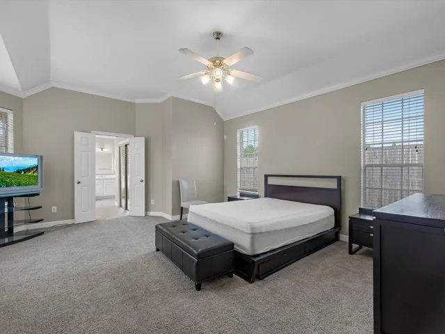 a spacious bedroom with a bed and a chandelier