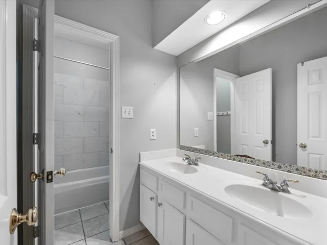 a bathroom with a double vanity sink mirror double and shower