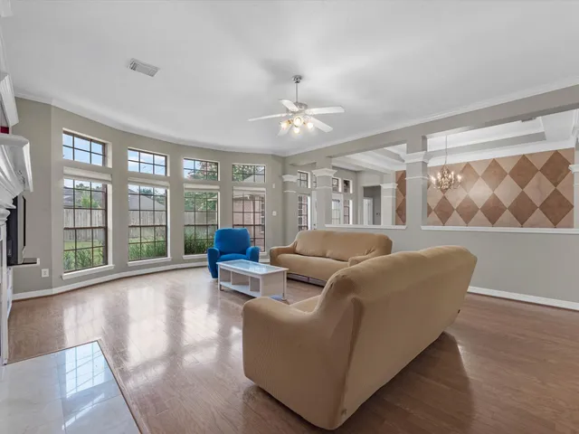 a living room with furniture and large windows