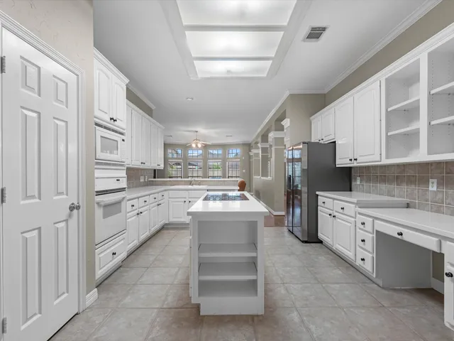 a kitchen with white cabinets and white appliances