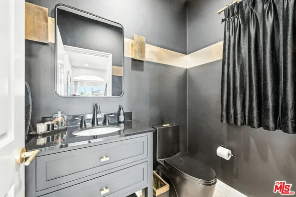 a bathroom with a toilet sink and mirror