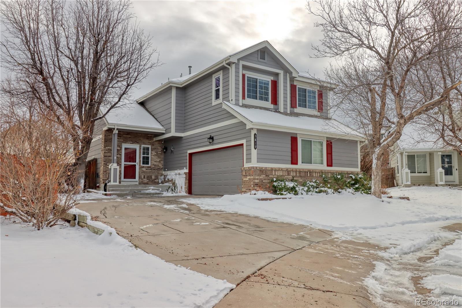 a front view of a house with a yard covered in snow