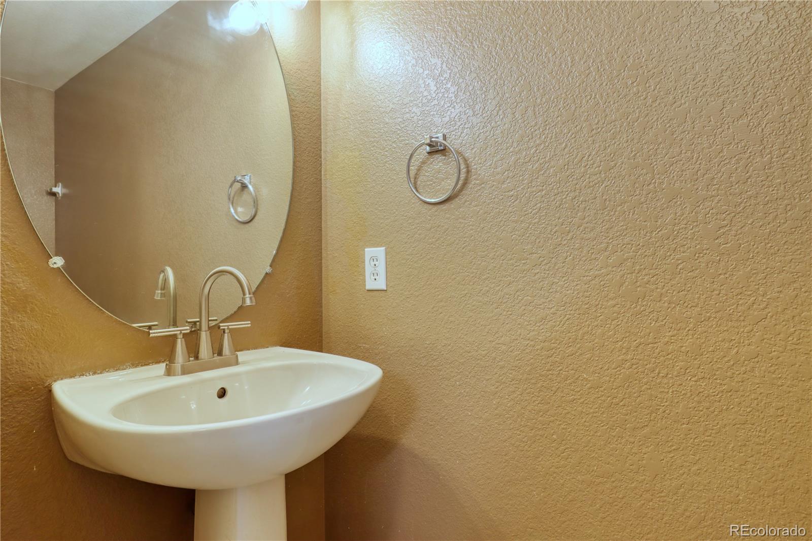 3819 South Rome Way Aurora, CO 80018 - Photo 13 of 32 a bathroom with a sink and mirror