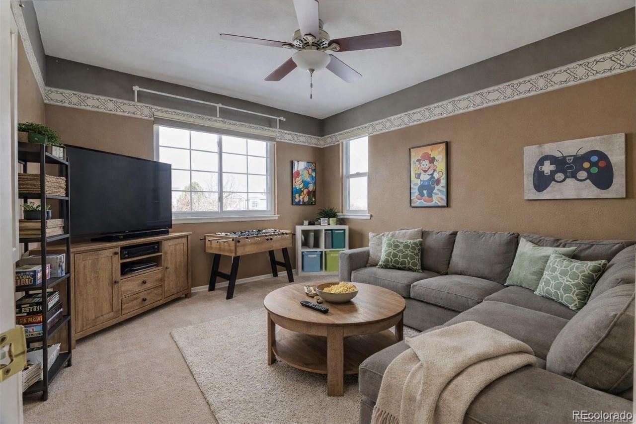 3819 South Rome Way Aurora, CO 80018 - Photo 22 of 32 a living room with furniture a flat screen tv and kitchen view