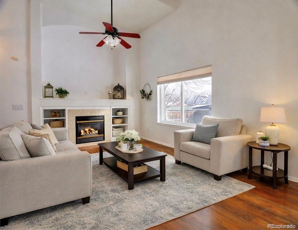 3819 South Rome Way Aurora, CO 80018 - Photo 3 of 32 a living room with furniture a fireplace and a window