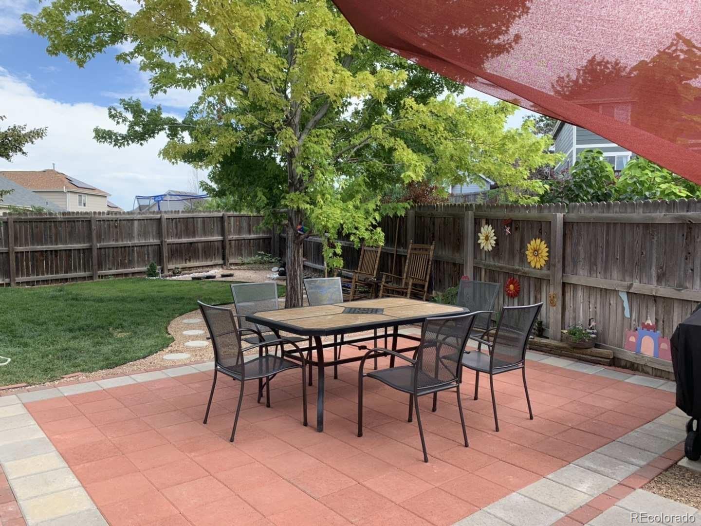 3819 South Rome Way Aurora, CO 80018 - Photo 32 of 32 a backyard of a house with table and chairs