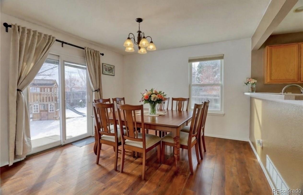 3819 South Rome Way Aurora, CO 80018 - Photo 4 of 32 a view of a dining room with furniture a chandelier and wooden floor