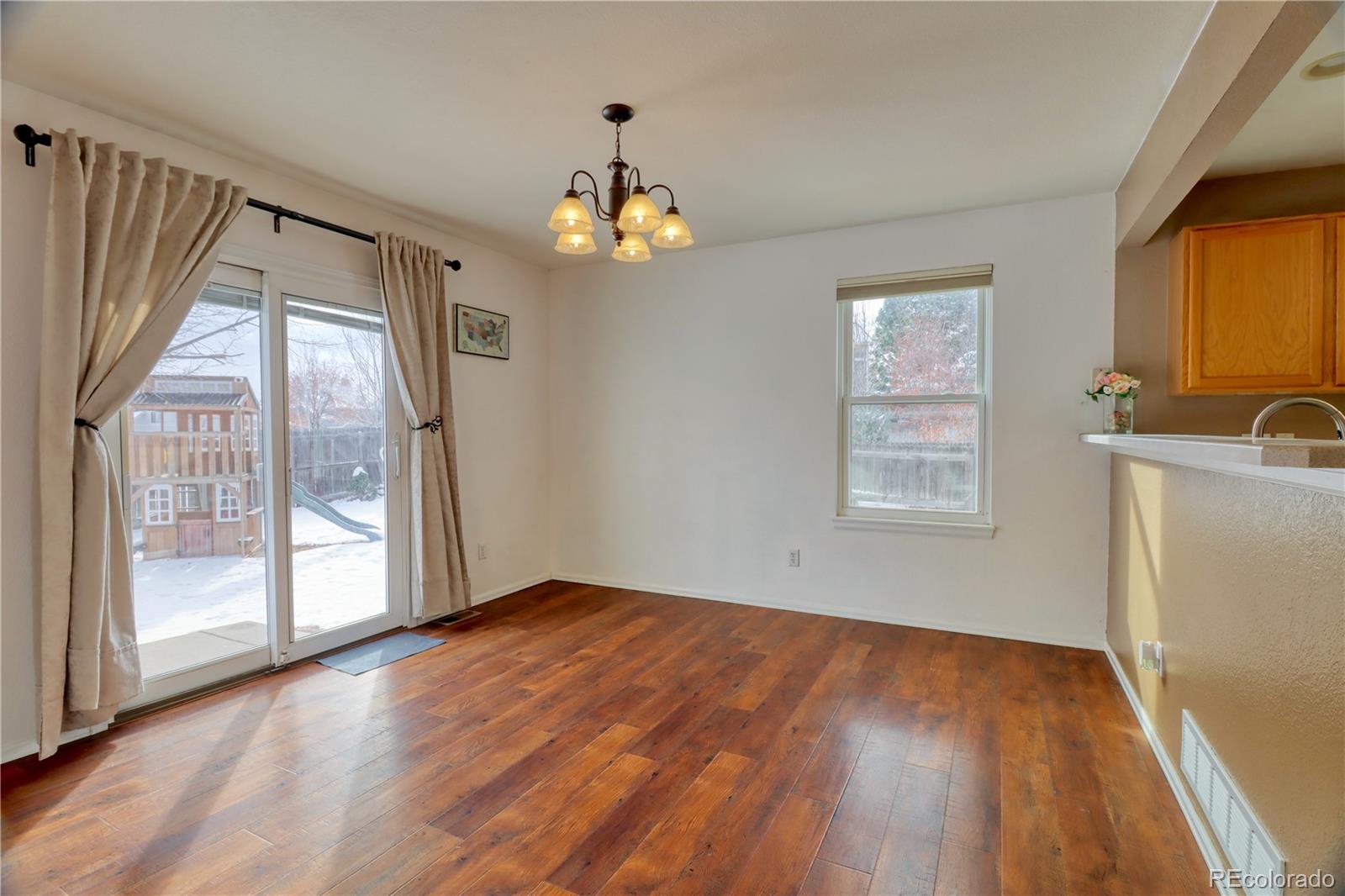 3819 South Rome Way Aurora, CO 80018 - Photo 5 of 25 an empty room with wooden floor and windows