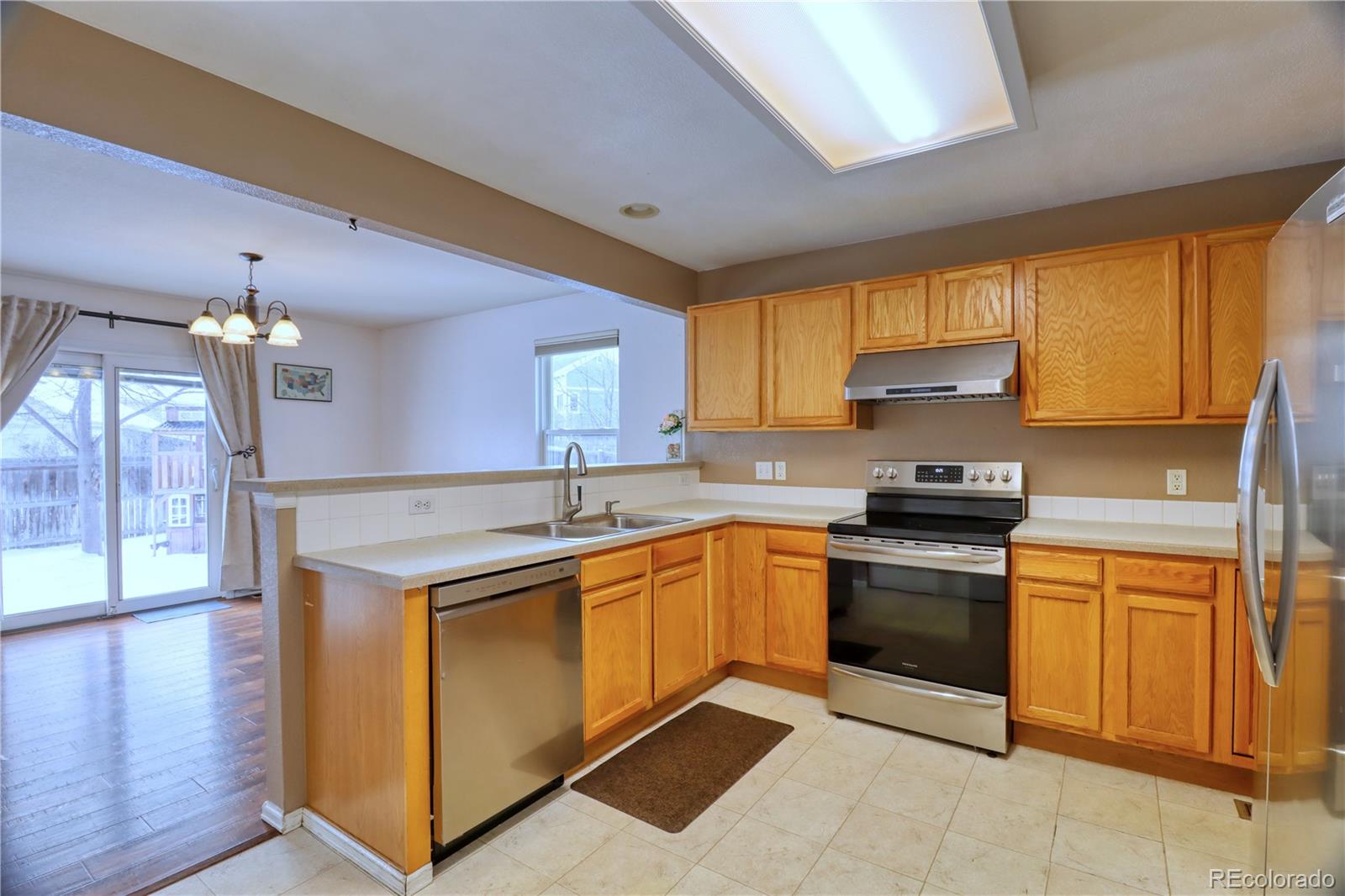 3819 South Rome Way Aurora, CO 80018 - Photo 9 of 25 a kitchen with a sink stove and microwave