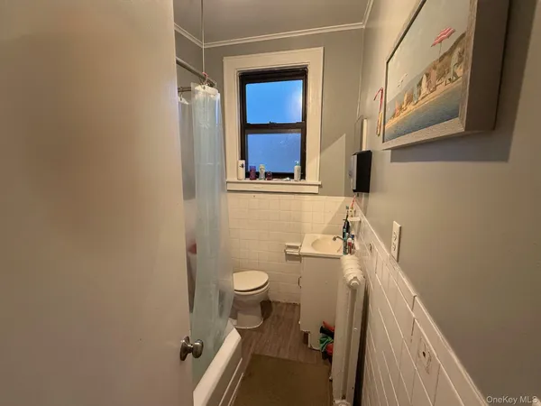 a bathroom with a sink a toilet a window and vanity