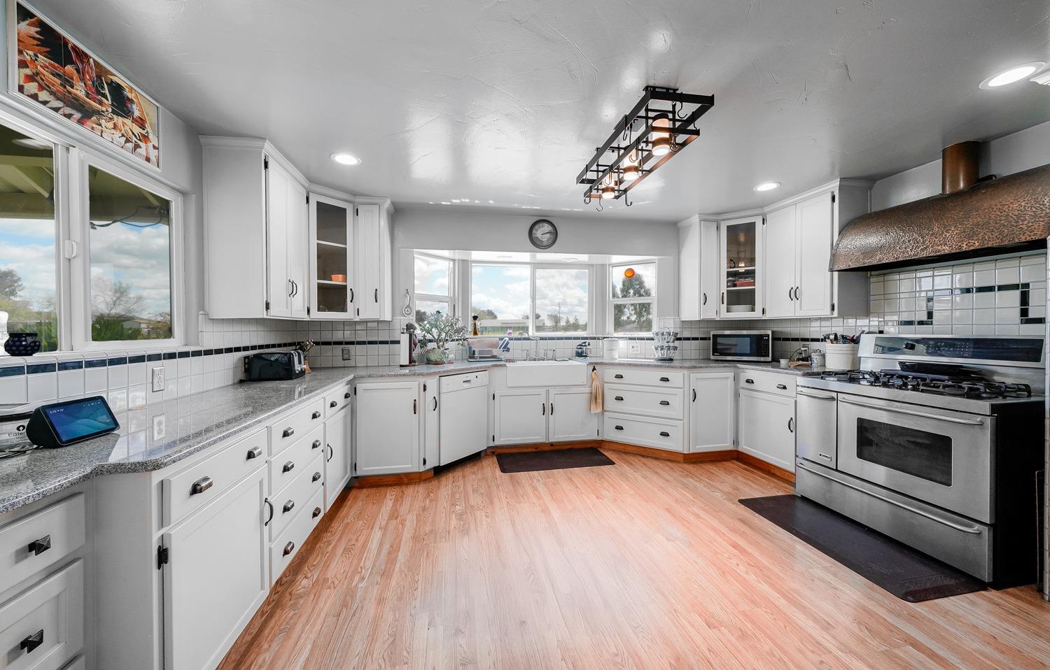 37491 Verde Avenue Madera, CA 93636 - Photo 2 of 66 a kitchen with stainless steel appliances white cabinets a sink a stove a refrigerator and a microwave