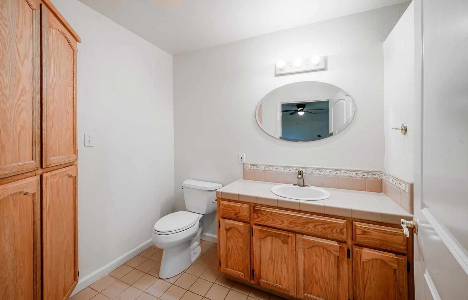 37491 Verde Avenue Madera, CA 93636 - Photo 44 of 66 a bathroom with a toilet a sink and mirror