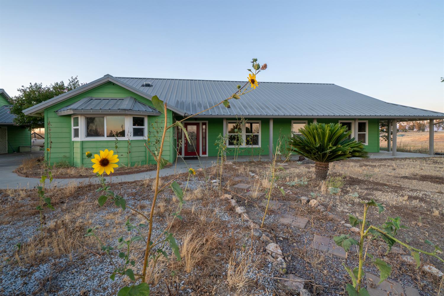 37491 Verde Avenue Madera, CA 93636 - Photo 60 of 66 a front view of a house with large trees and a yard