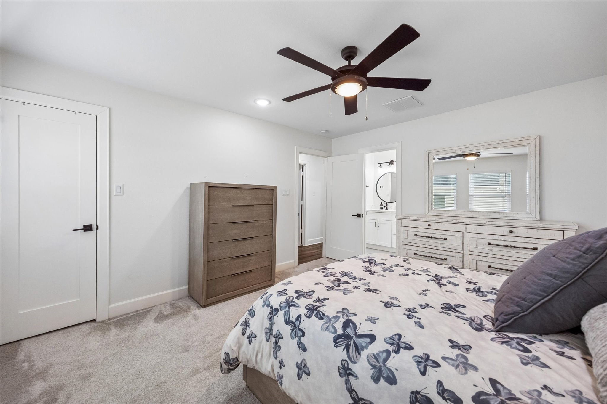 1420 Indiana Street Houston, TX 77006 - Photo 20 of 31 This bedroom features a clean, modern design with neutral tones. The room is well-lit with recessed lighting and has an ensuite bathroom visible through an open door.